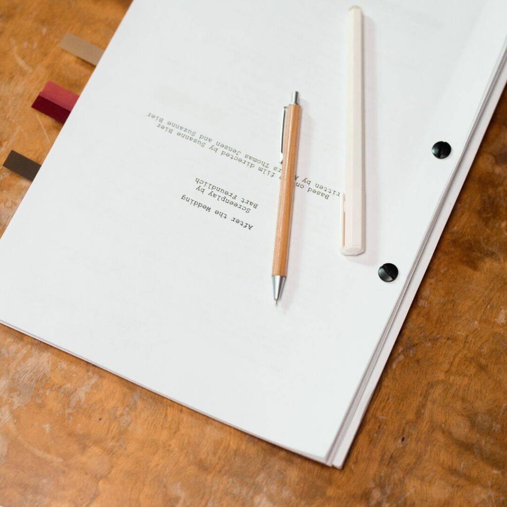 Manuscript on table top with two pens sitting on top of it