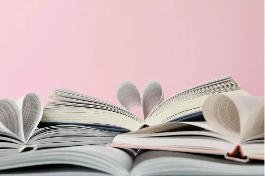 Three books are resting on a surface against a light pink background. Their pages are
folded in the shape of hearts.