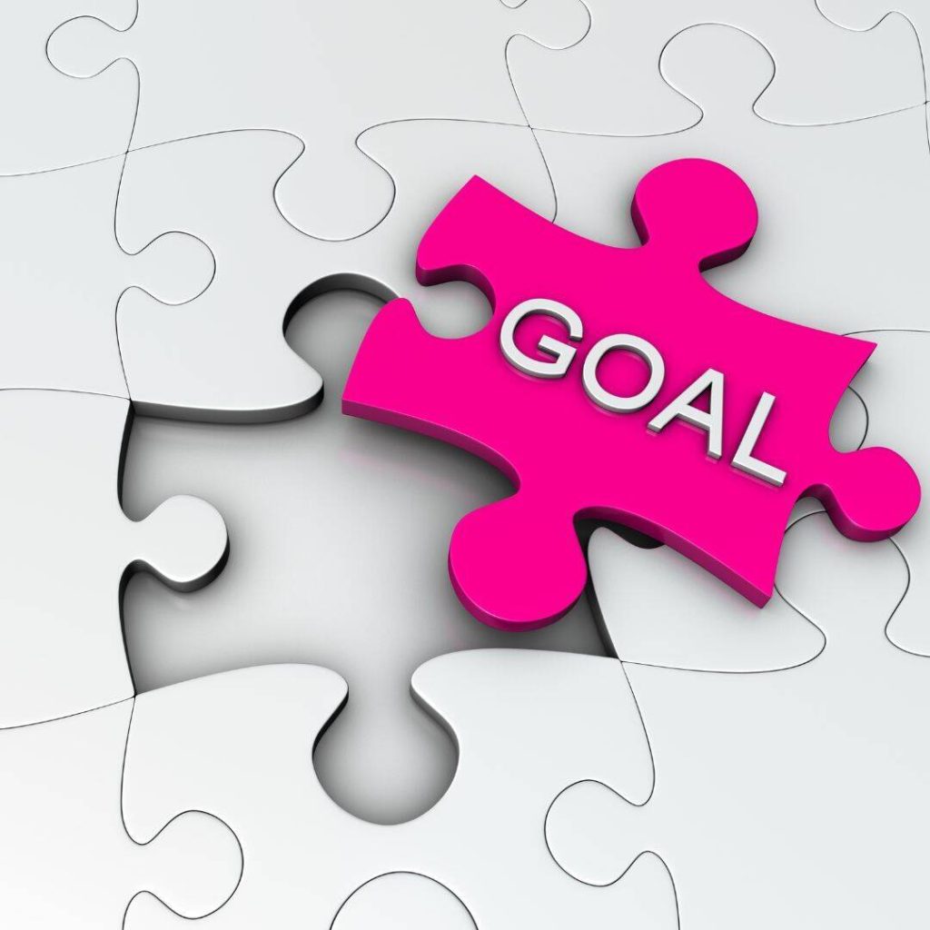 Hot pink puzzle piece that says Goal written in white.