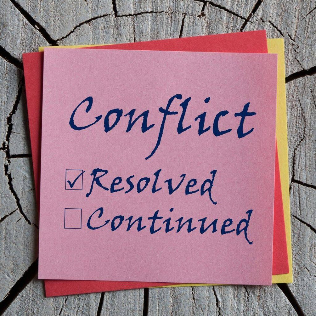 Conflict Resolved /Continued written in black marker on a hot pink post-it.