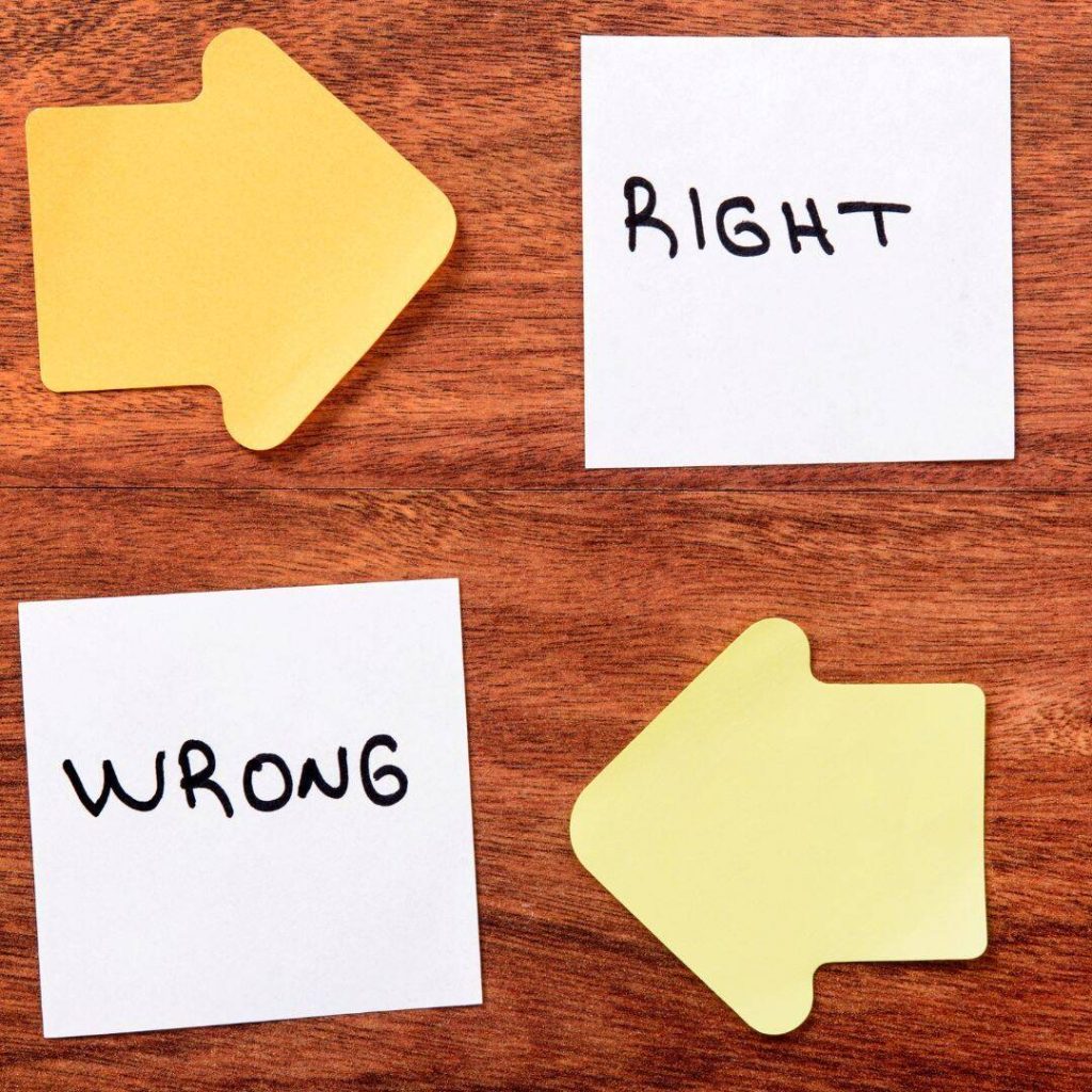 Right written in black marker on a white post it.  Wrong written in black marker on white post it.  Yellow arrow pointing to right post it and yellow arrow pointing to wrong post it.  Both post its laid out on brown wooden tabletop. 