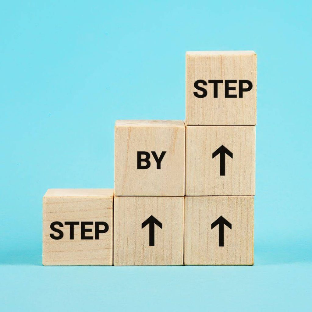6 wooden blocks formed into a staircase to demonstrate progress as step by step.