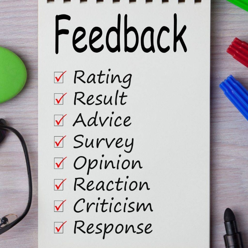 The word feedback is written in huge black writing on top of white notebook paper with no lines.  

The words Rating, Result, Advice, Survey, Opinion, Reaction, Criticism, and Response are written below feedback in smaller letters.  Check boxes are placed beside each word with red checks in each box beside each word. 